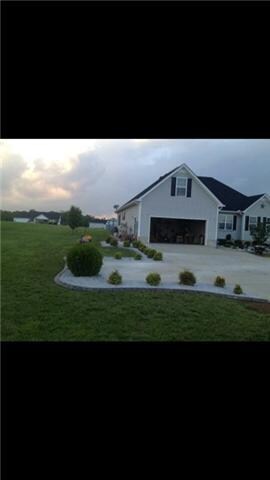 BEAUTIFULLY LANDSCAPED WITH ROCK MULCH AND BEAUTIFUL CONCRETE CURBS AROUND ALL THE LANDSCAPED AREAS.