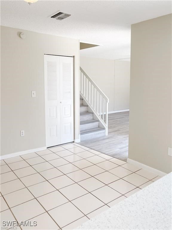 Unfurnished room featuring a textured ceiling, vis