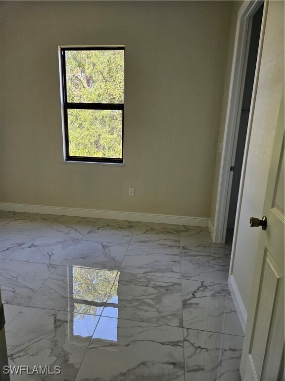 Empty room featuring light marble finish floors an