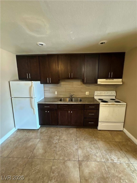 Kitchen with white appliances, a sink, under cabin
