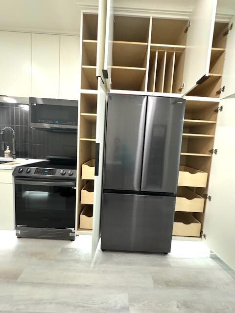 Kitchen with stainless steel appliances, open she