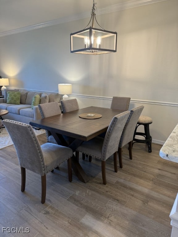 Dining space featuring crown molding and wood finished floors