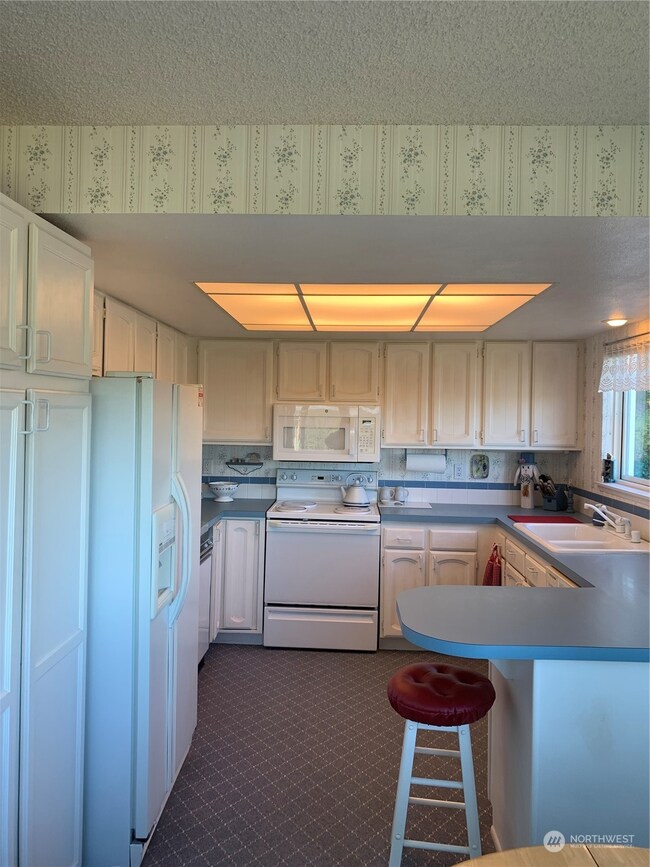 Kitchen with ample cabinet space, all appliances stay, and view over the sink~