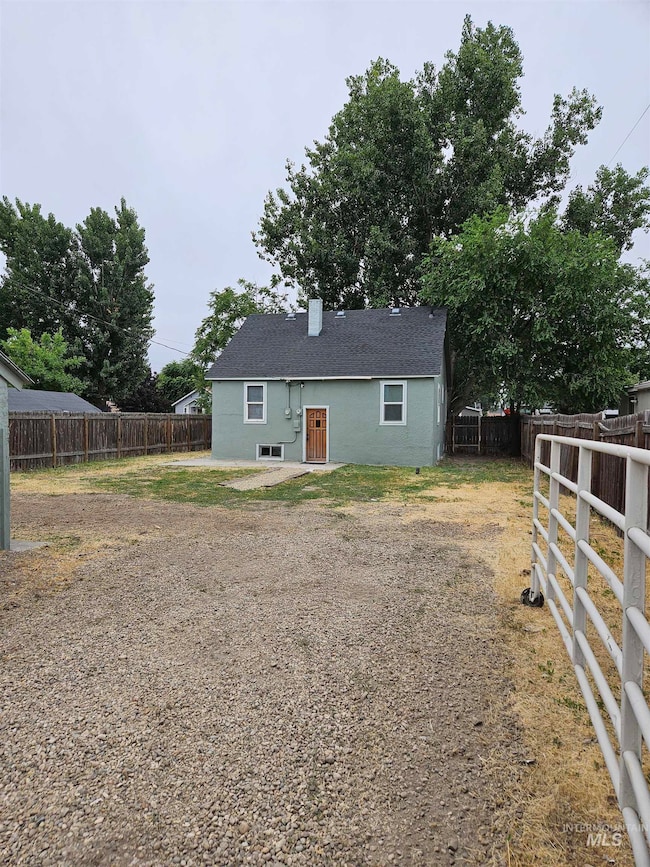 Back of property featuring a fenced backyard and a chimney