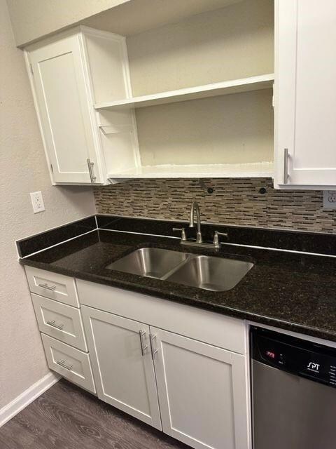 Kitchen featuring dishwasher, white cabinetry, ba