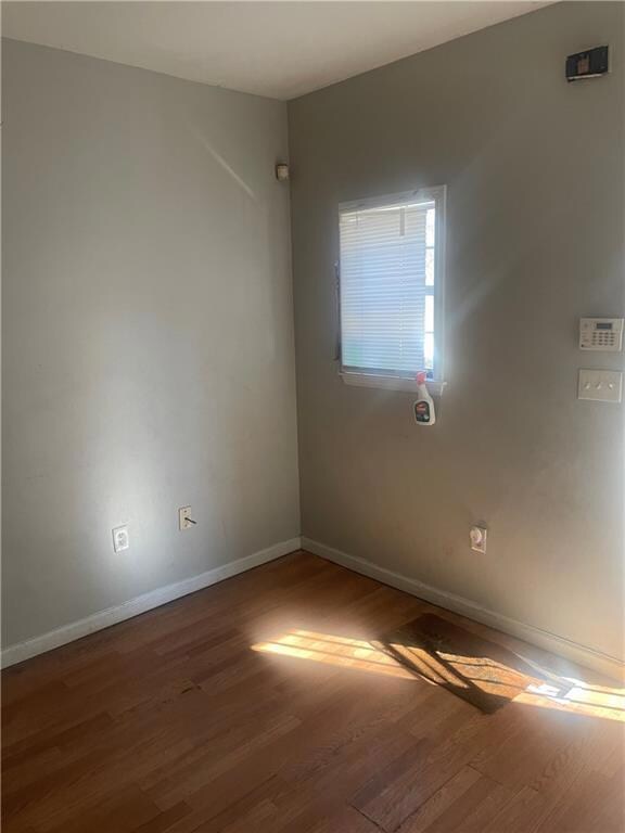Empty room featuring hardwood / wood-style floorin
