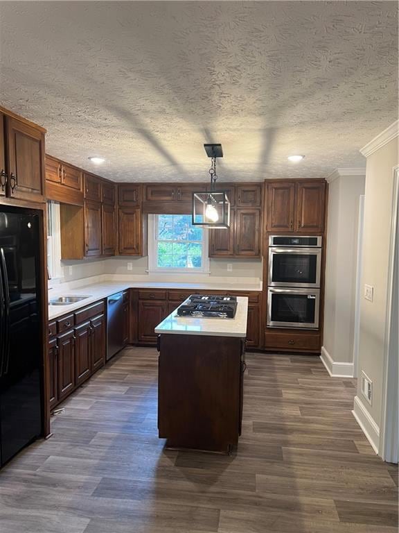 Kitchen with light countertops, hanging light fixtures, multiple ovens, fridge, and a textured ceiling (all appliances new excepting refrigerator)