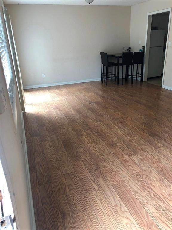 Unfurnished room featuring wood finished floors and baseboards