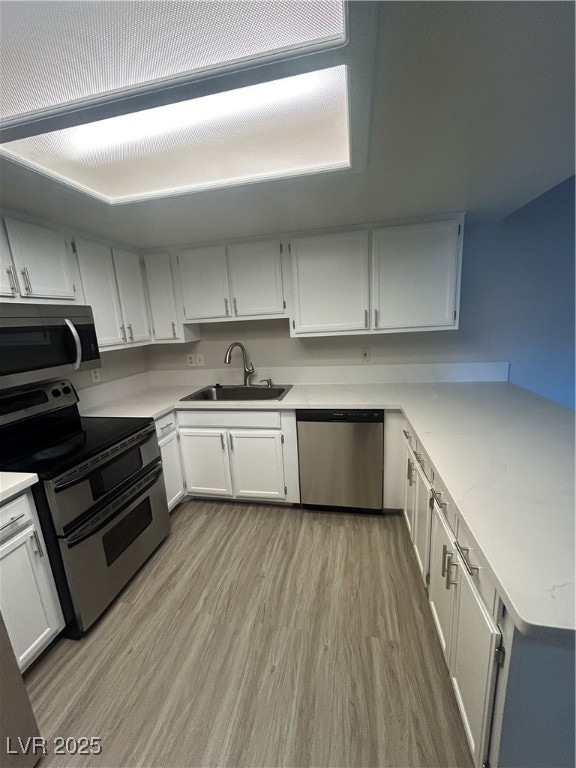 Kitchen featuring light wood finished floors, a si