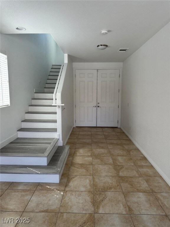 Stairway with visible vents, tile patterned floori