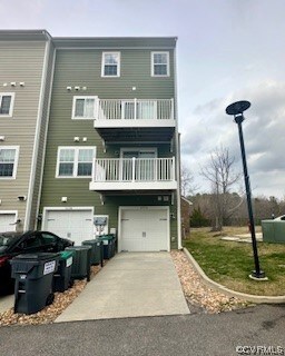 View of back of home with a garage, driveway, and