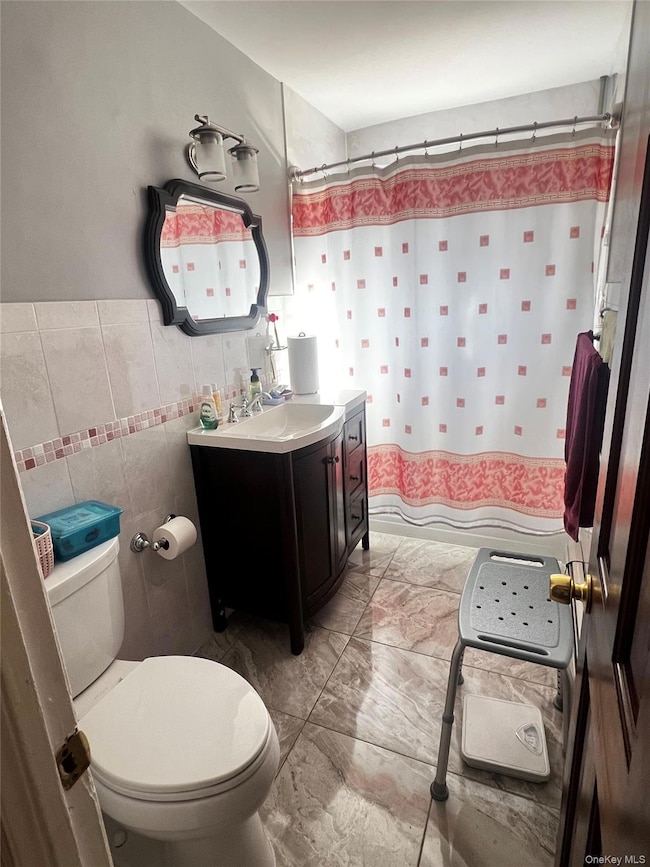 Bathroom with vanity and tile walls