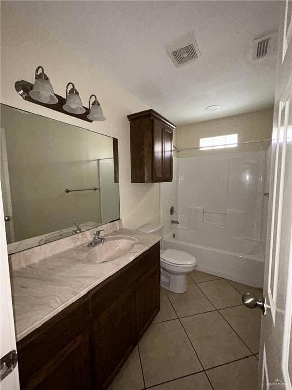 Bathroom featuring toilet, vanity, tile patterned flooring, and shower / washtub combination