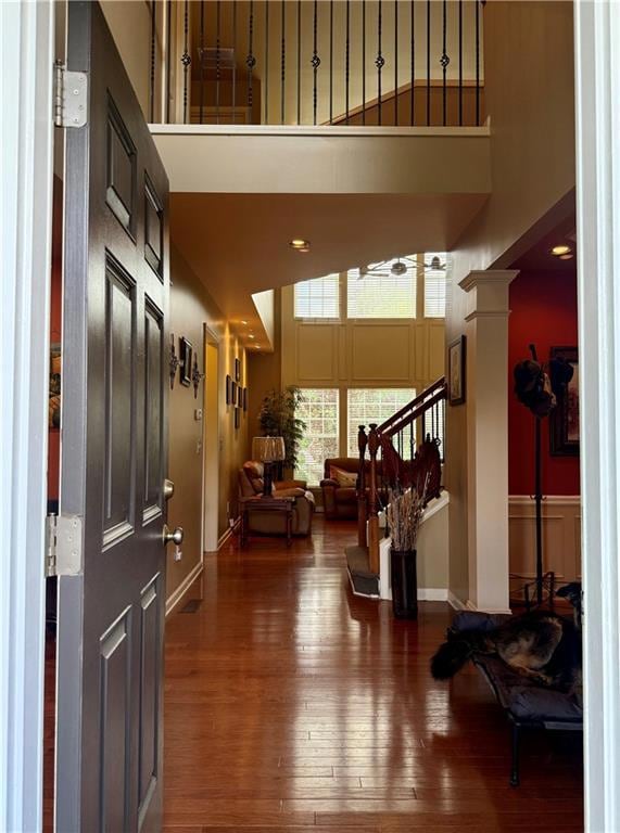 Entrance foyer featuring a towering ceiling, hardwood / wood-style floors, stairs, and baseboards