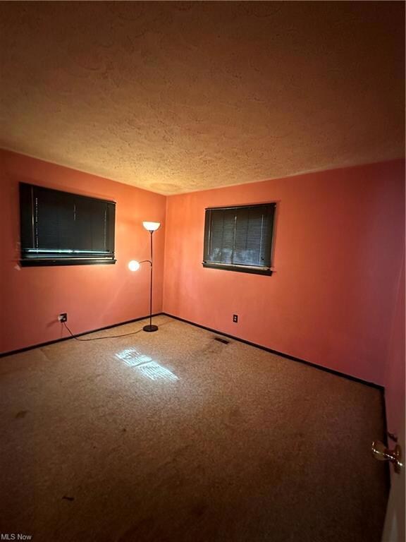 Unfurnished room featuring a textured ceiling and 