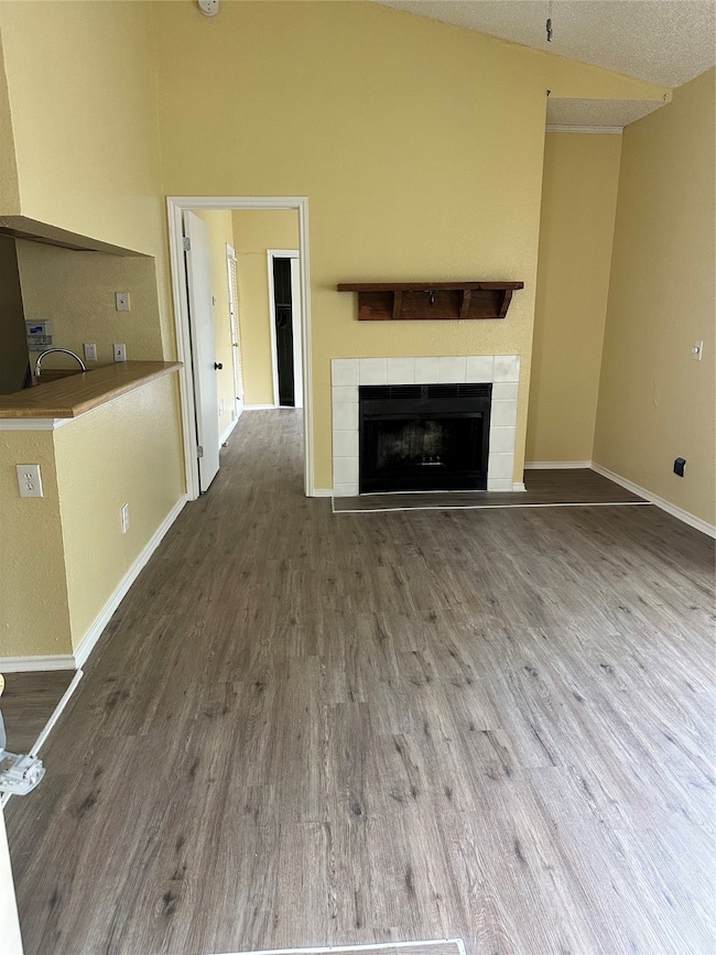 Unfurnished living room featuring wood finished floors and a fireplace