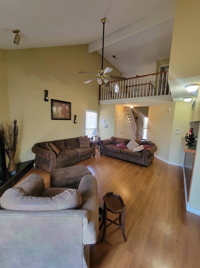 Living room featuring beamed ceiling, high vaulted