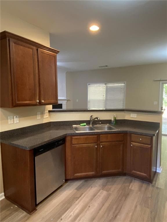Kitchen featuring a sink, dark countertops, light 
