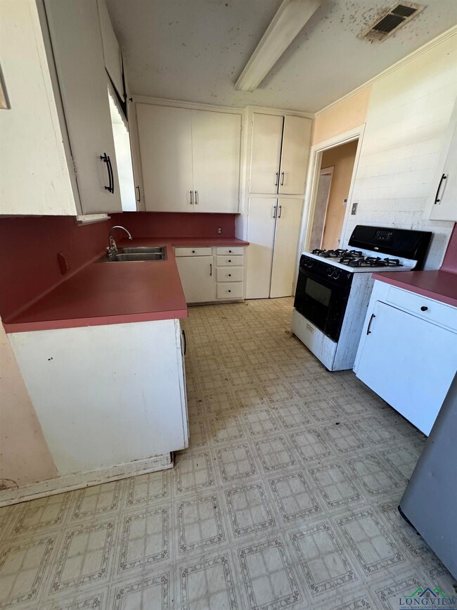 Kitchen with range with gas stovetop, light floors