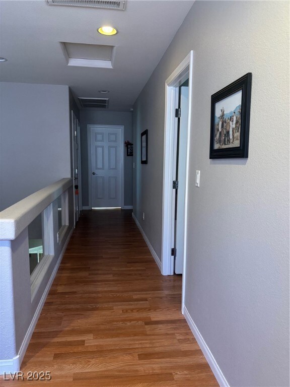 Corridor featuring attic access and light wood-style floors