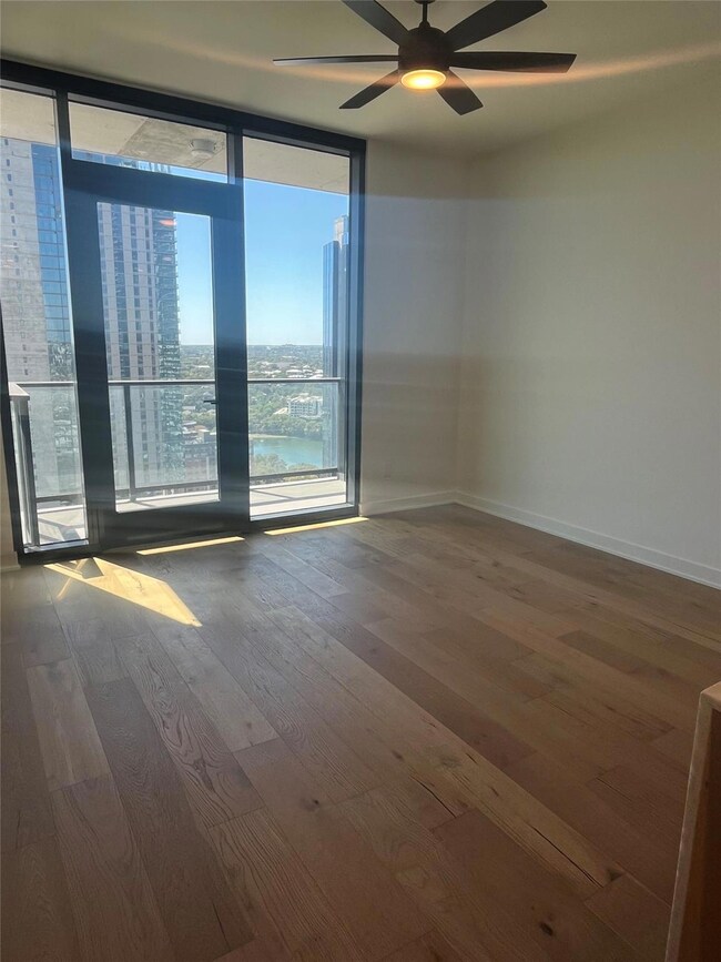 Empty room with floor to ceiling windows, wood fi