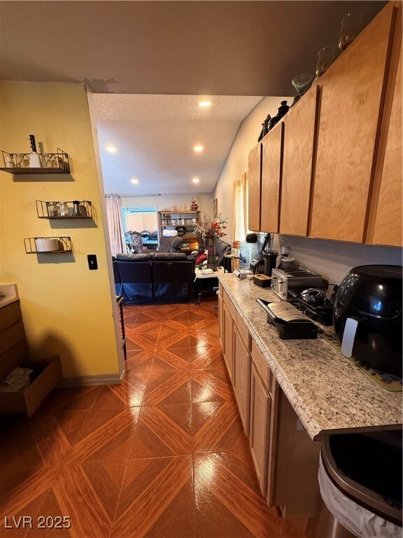 Kitchen with light countertops, lofted ceiling, an