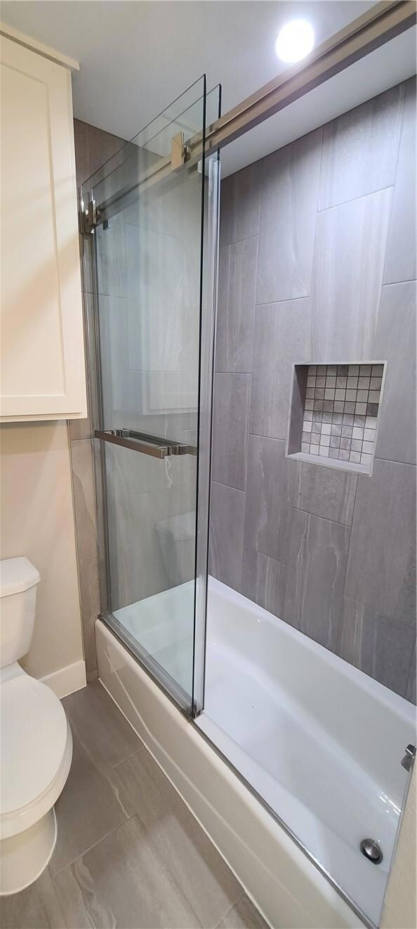 Bathroom featuring toilet, combined bath / shower