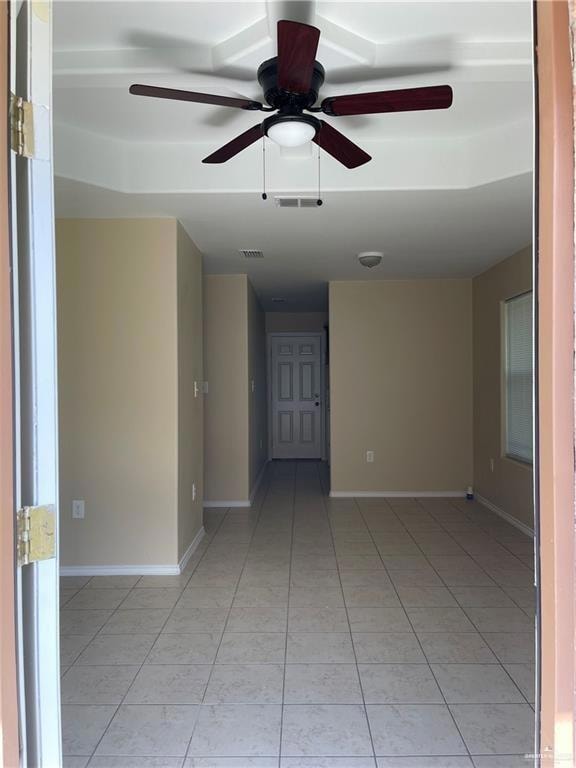 Spare room with light tile patterned floors, ceiling fan, and baseboards
