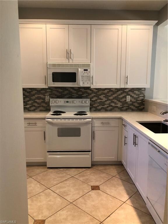 Kitchen with Quartz counters and Glass tile backsp