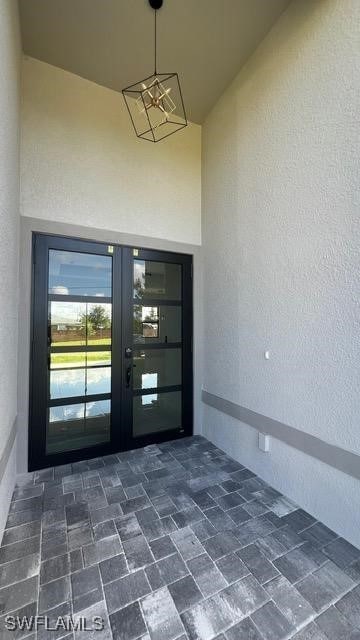 View of exterior entry with stucco siding and fren