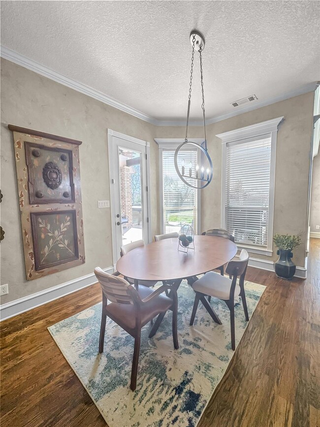 Dining area with crown molding, a textured ceiling