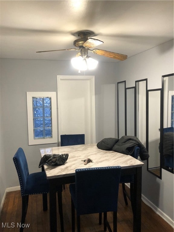 Dining area with dark wood finished floors and a ceiling fan