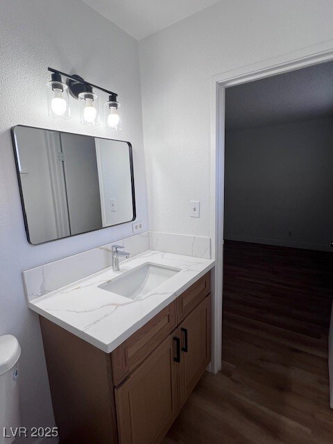 Bathroom with dark wood finished floors and vanity
