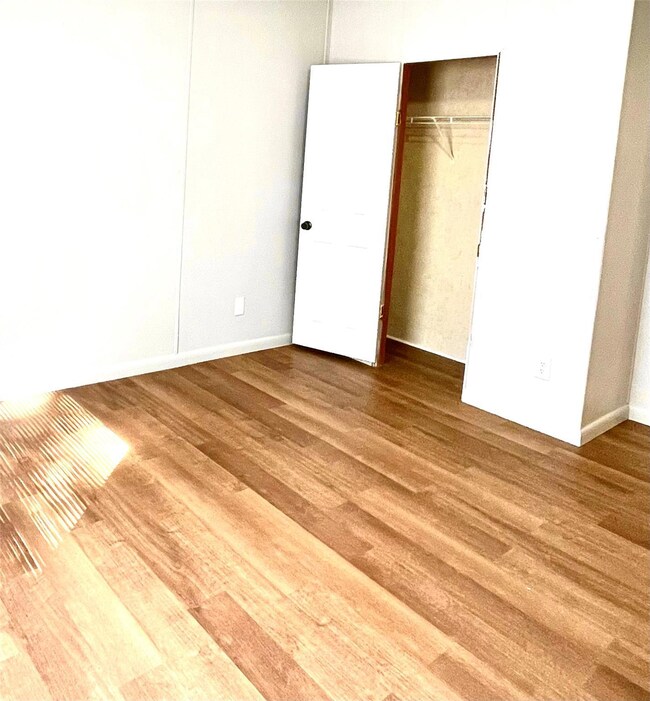 Unfurnished bedroom featuring hardwood / wood-styl