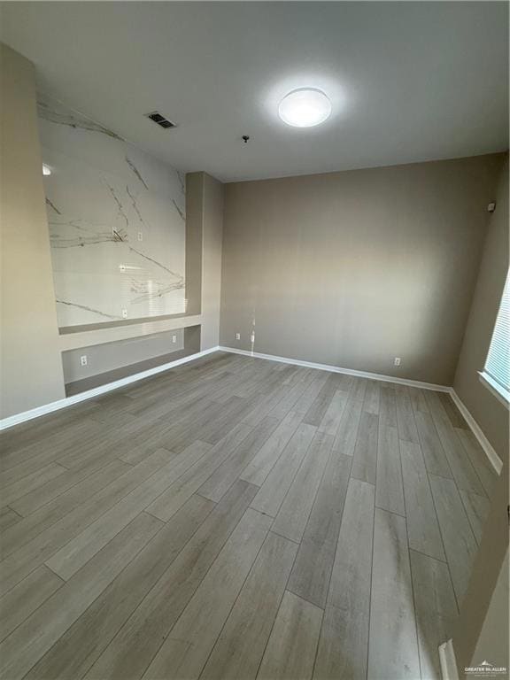 Unfurnished room with wood finished floors and baseboards