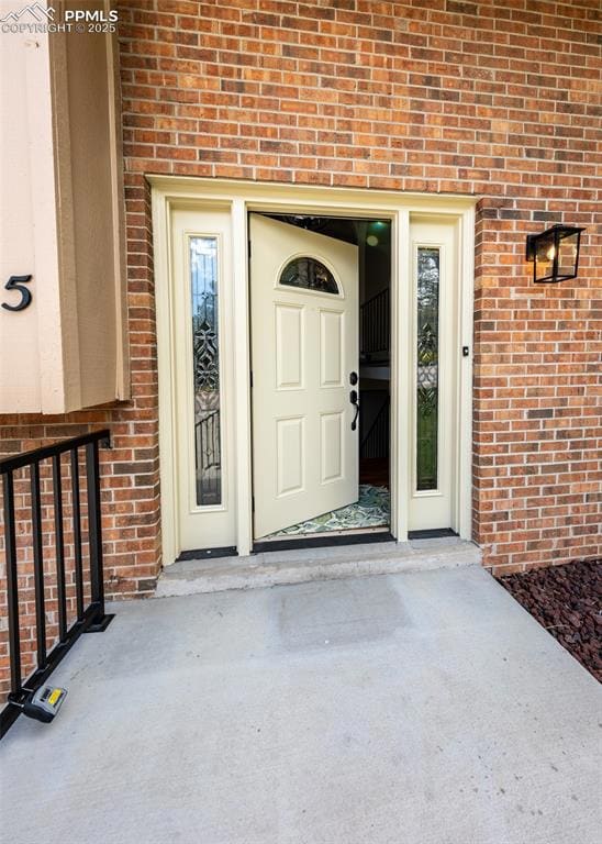 Doorway to property featuring brick siding