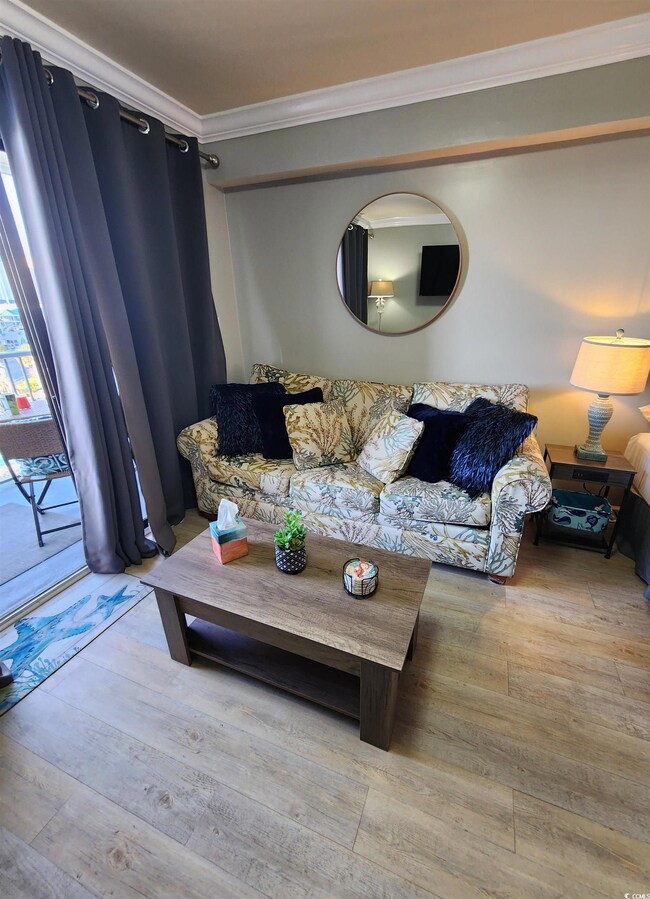Living room featuring ornamental molding and light wood-type flooring