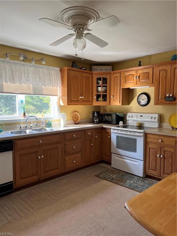 Kitchen featuring brown cabinets, light carpet, di