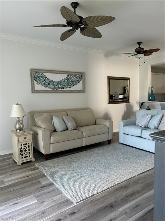 Living room featuring wood-type flooring, crown mo