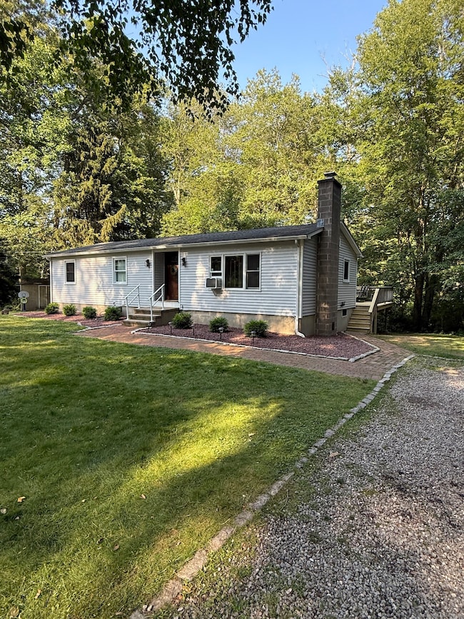 Gravel driveway leads to front door and rear deck.