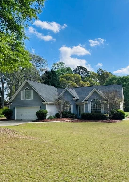 Ranch-style house with a garage, driveway, and a f