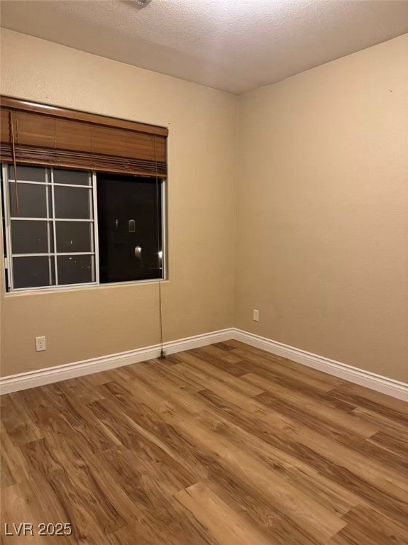 Unfurnished room featuring wood finished floors and a textured ceiling