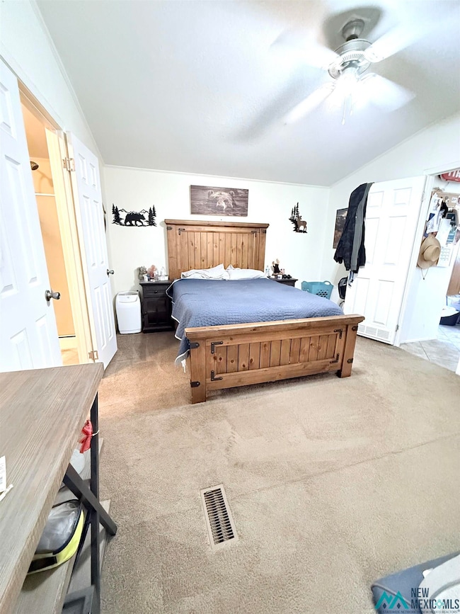 Bedroom featuring light carpet, ceiling fan, and lofted ceiling