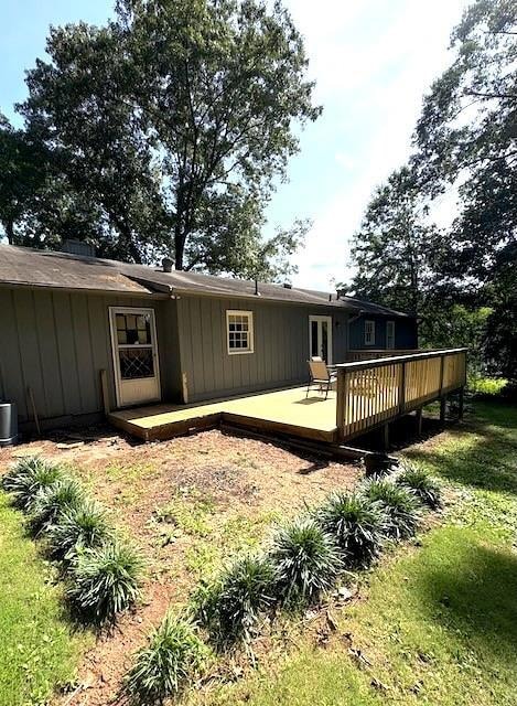Rear view of house with a deck and board and batten siding