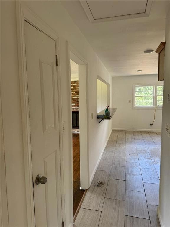Corridor featuring wood tiled floors and baseboards