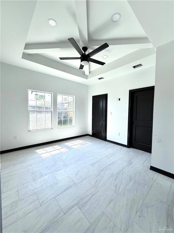 Empty room featuring baseboards, ceiling fan, a raised ceiling, and recessed lighting