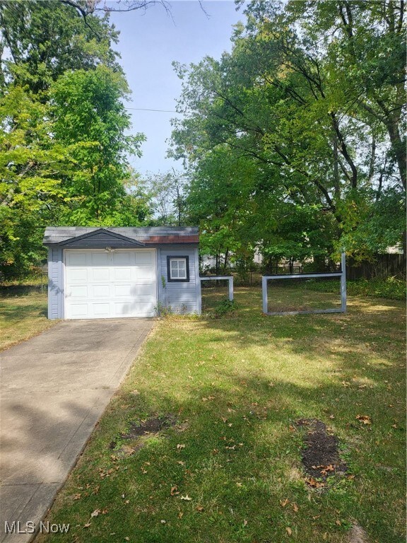 View of front of property featuring a front yard and a garage