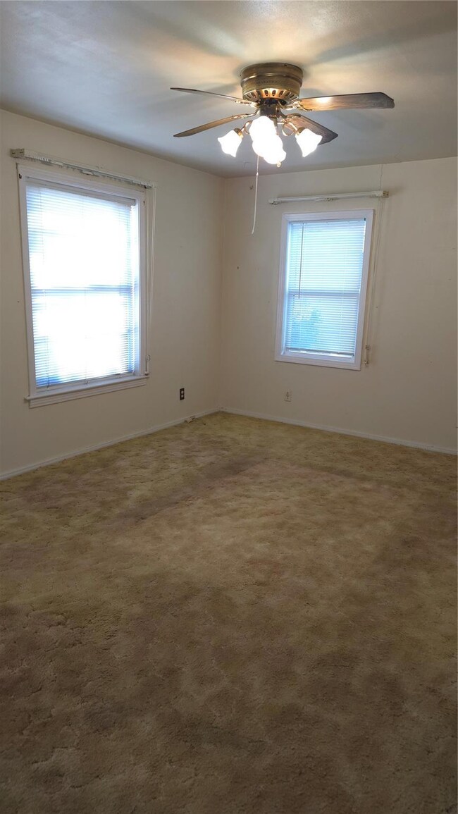 empty room with baseboards, carpet and ceiling fan