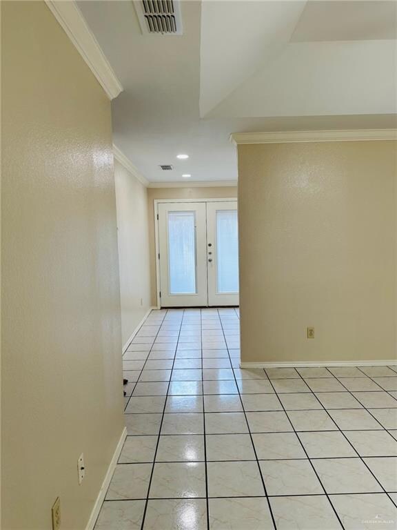 Corridor featuring ornamental molding, french doors, and light tile patterned floors