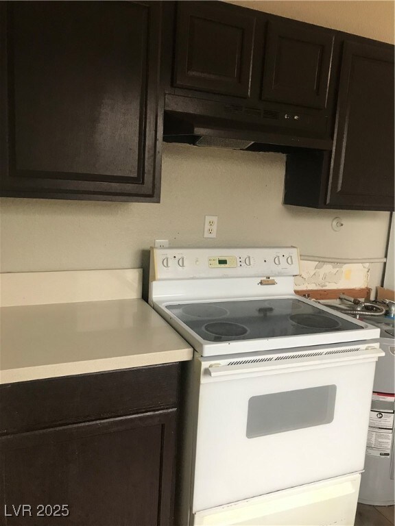 Kitchen with ventilation hood, range with electric cooktop, and light countertops